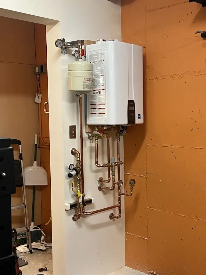 Plumbing technician inspecting water heater connections in Cloverly